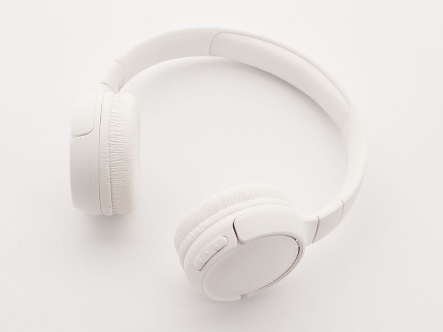 Auriculares de diadema blancos sobre un fondo claro.